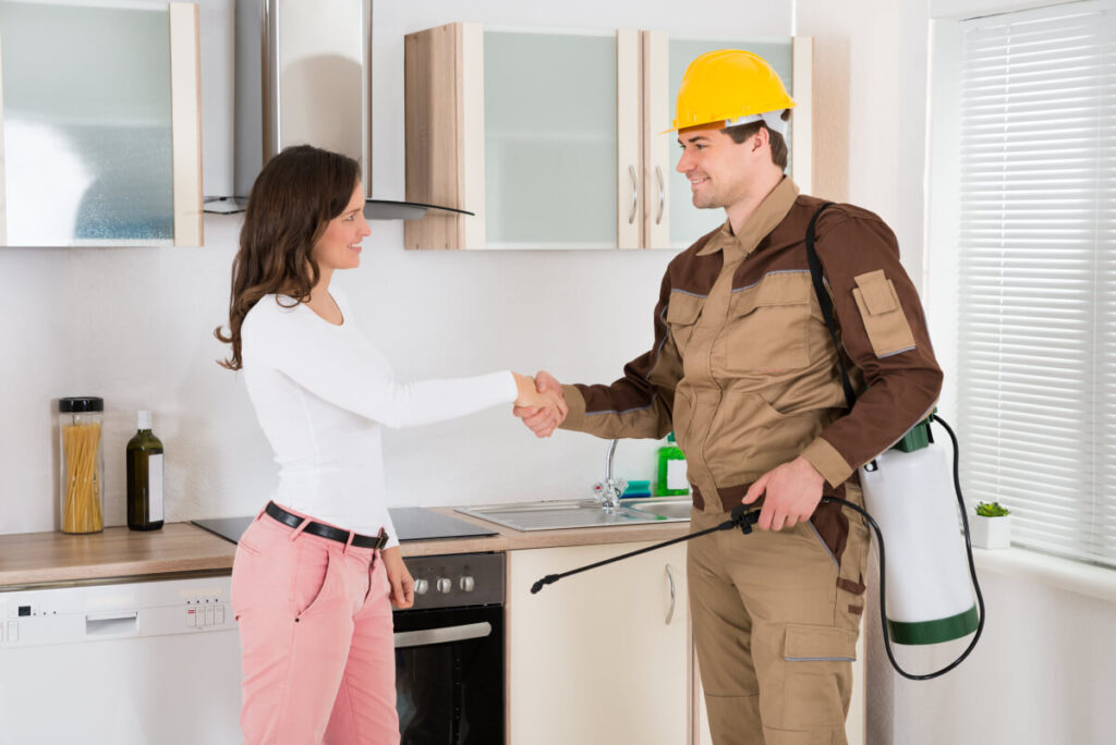 professional pest control worker shaking hands with customer over a job well done doing the ant control 